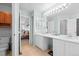 Well-lit bathroom with double vanity and tile flooring, connecting to the Primary bedroom at 2715 E 131St Ave, Thornton, CO 80241