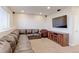 Finished basement featuring a leather sectional couch, media console, a TV, and ambient lighting at 3925 W 149Th Ave, Broomfield, CO 80023