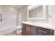 Bright bathroom featuring a vanity with dark wood cabinets and a shower with white tile surround at 3925 W 149Th Ave, Broomfield, CO 80023