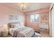 Cozy bedroom with soft pink walls, a large window, a comfortable bed, and a stylish chandelier at 3925 W 149Th Ave, Broomfield, CO 80023