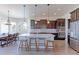 Bright, open kitchen featuring a marble island, stainless steel appliances, and dark wood cabinets with dining area at 3925 W 149Th Ave, Broomfield, CO 80023