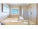Bright main bathroom featuring a soaking tub, glass shower, and modern fixtures at 3925 W 149Th Ave, Broomfield, CO 80023
