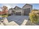 Charming two-story home featuring a three-car garage, manicured lawn, and stone accents at 6673 Mentha Dr, Castle Rock, CO 80108