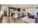 Open-concept kitchen features stainless steel appliances, granite countertops, a breakfast bar, and wood floors at 6673 Mentha Dr, Castle Rock, CO 80108