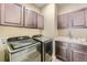 Well-lit laundry room featuring a sink, modern washer and dryer, and ample cabinet space at 6673 Mentha Dr, Castle Rock, CO 80108