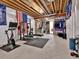 Unfinished basement gym with various exercise machines, weights and open ceilings at 11464 Stonewash St, Littleton, CO 80125