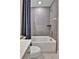 Modern bathroom with gray tiled shower, tub, and coordinated blue shower curtain at 11464 Stonewash St, Littleton, CO 80125