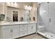 Elegant bathroom with double vanity, walk-in shower, and closet in mirror at 11464 Stonewash St, Littleton, CO 80125