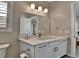 Updated half bath with a white vanity, modern lighting, and stylish mirror at 11464 Stonewash St, Littleton, CO 80125