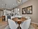 Elegant dining area with a round wooden table, comfortable seating, and modern artwork at 11464 Stonewash St, Littleton, CO 80125