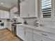 Modern kitchen with stainless steel appliances, white cabinetry, and elegant countertop space at 11464 Stonewash St, Littleton, CO 80125