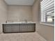 Well-lit laundry room features modern cabinetry with a sink, countertops, and a window at 11464 Stonewash St, Littleton, CO 80125