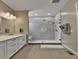 Bright bathroom with double vanity and glass-enclosed tiled shower at 11464 Stonewash St, Littleton, CO 80125