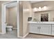 Bathroom featuring vanity, toilet, and a view of the walk-in closet at 11464 Stonewash St, Littleton, CO 80125