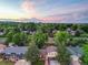 An aerial view showcases a home with mature trees and a serene neighborhood at sunset at 9123 W Arbor Ave, Littleton, CO 80123