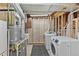 Spacious basement laundry area with washer, dryer, utility sink, and visible mechanical systems at 9123 W Arbor Ave, Littleton, CO 80123