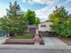Charming split-level home featuring a brick facade, lush landscaping, and inviting curb appeal at 9123 W Arbor Ave, Littleton, CO 80123