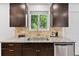 Modern kitchen features granite countertops, stainless steel appliances, and brown cabinetry at 9123 W Arbor Ave, Littleton, CO 80123