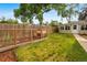 Spacious backyard has a chicken coop, grass, and a wood fence for privacy at 404 S Jasmine St, Denver, CO 80224