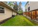 A grassy backyard features space between neighboring properties, enhanced with mulch and a wooden fence at 404 S Jasmine St, Denver, CO 80224