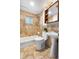Bright bathroom features a bath tub with shower, tiled walls, and vanity with a mirrored medicine cabinet at 404 S Jasmine St, Denver, CO 80224