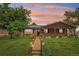 Charming red brick home featuring a well-manicured lawn and inviting walkway at sunset at 4293 Graham Ct, Boulder, CO 80305