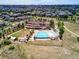 Aerial view of a community clubhouse with a pool, lounge areas, and landscaping in a well-planned residential area at 7173 S Shady Grove Ct, Aurora, CO 80016
