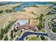 Aerial view of a community clubhouse with a large pool, expansive lawn, and manicured landscaping at 7173 S Shady Grove Ct, Aurora, CO 80016