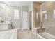 Bright bathroom featuring a glass shower with seat, soaking tub, and a neutral color palette at 7173 S Shady Grove Ct, Aurora, CO 80016