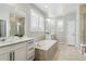 Bright bathroom with double vanities, soaking tub, and modern fixtures at 7173 S Shady Grove Ct, Aurora, CO 80016