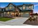 Lovely two-story home with stone detailing, warm exterior lights, and an attached two-car garage at 7173 S Shady Grove Ct, Aurora, CO 80016