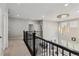 Open landing area with wrought iron railing and view of living spaces at 7173 S Shady Grove Ct, Aurora, CO 80016