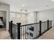Upper level landing with modern chandelier and view of the living room below at 7173 S Shady Grove Ct, Aurora, CO 80016
