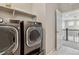 Modern laundry room equipped with stainless steel washer and dryer and ample shelving space at 7173 S Shady Grove Ct, Aurora, CO 80016