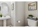 Charming powder room featuring pedestal sink, decorative art and thoughtful design elements at 7173 S Shady Grove Ct, Aurora, CO 80016