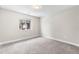 Empty bedroom features neutral walls, carpet, a large window, and updated fixtures at 1655 Yates St, Denver, CO 80204