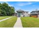 Charming home featuring gray brick, lush green lawn, walkway and vibrant blue front door with covered porch at 1655 Yates St, Denver, CO 80204