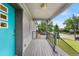 Inviting front porch with gray brick exterior, stylish railing, and a pop of color from the bright blue door at 1655 Yates St, Denver, CO 80204