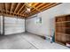 Spacious garage with concrete floor, white brick walls, and storage shelving at 1655 Yates St, Denver, CO 80204