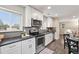 Bright kitchen featuring white cabinets, stainless steel appliances, dark countertops and gray backsplash at 1655 Yates St, Denver, CO 80204