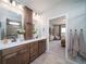 Bathroom featuring a dual sink vanity with dark wood cabinets, white countertop and a view to the bedroom at 21945 E 51St Dr, Aurora, CO 80019