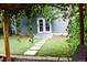 Picturesque backyard view featuring a stone path, artificial grass, lush foliage, and a charming patio at 3427 W 29Th Ave, Denver, CO 80211