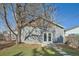 Backyard view of the detached garage with white doors, steps, and a well-maintained lawn and mature tree at 3427 W 29Th Ave, Denver, CO 80211
