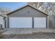 Detached two car garage with white garage doors and gray siding situated at the end of a driveway at 3427 W 29Th Ave, Denver, CO 80211