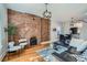 Inviting living room with exposed brick wall, hardwood floors, and a stylish black leather sofa at 3427 W 29Th Ave, Denver, CO 80211