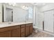 Bathroom features a double sink vanity, large mirror, shower, and modern fixtures in a bright space at 18951 E 96Th Pl, Commerce City, CO 80022