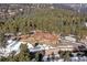 An aerial view shows a home with a brown roof surrounded by trees with lingering winter snow at 1391 S Winston Dr, Golden, CO 80401