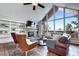 Sun-filled living room with a stone fireplace, large windows offering expansive views, and comfortable seating at 1391 S Winston Dr, Golden, CO 80401