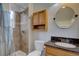 Bathroom with shower, tile surround, wooden cabinet and granite countertop sink at 17912 E Milan Pl, Aurora, CO 80013