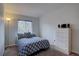 Cozy bedroom featuring a large window, comfortable bed, and a dresser for ample storage at 17912 E Milan Pl, Aurora, CO 80013